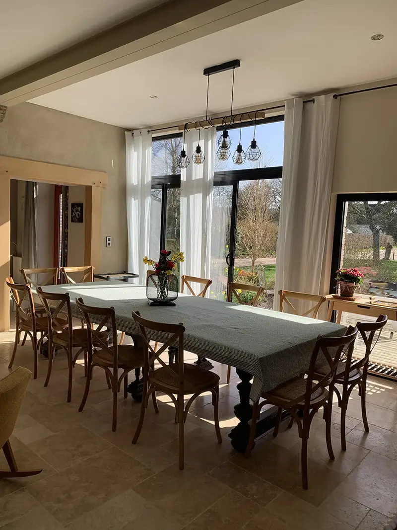 Salle de vie avec poêle à bois et vue sur le jardin